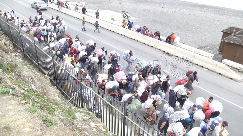 La fila de porteadores sustituye a la de coches en la carretera de la frontera