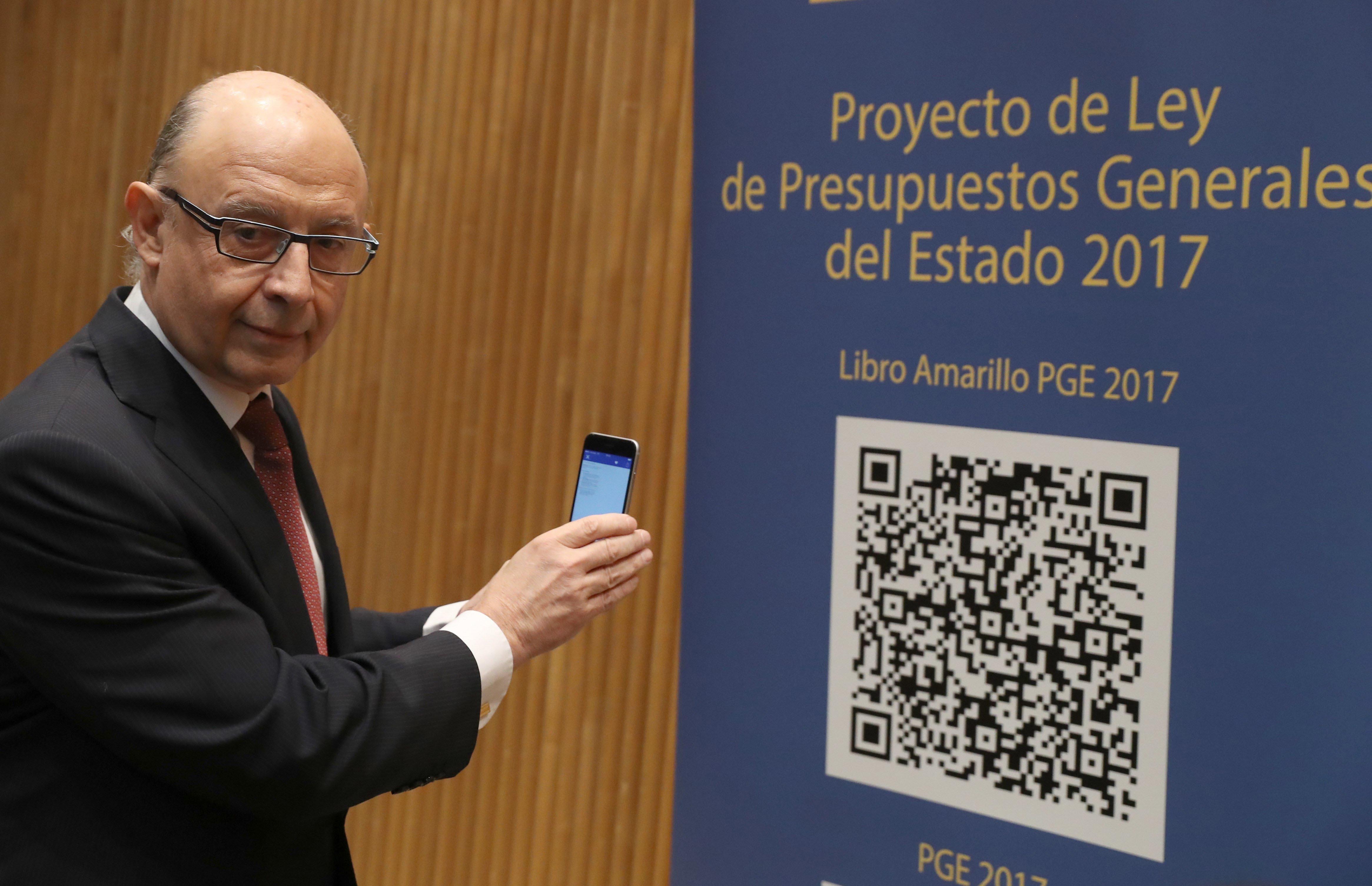GRA062. MADRID, 04/04/2017.- El ministro de Hacienda, Cristóbal Montoro, escanea con el móvl el código QR del proyecto de Ley de Presupuestos Generales del Estado (PGE) para 2017, poco antes de la rueda de prensa que ha ofrecido hoy en el Congreso para presentarlo. EFE/J. J. Guillén