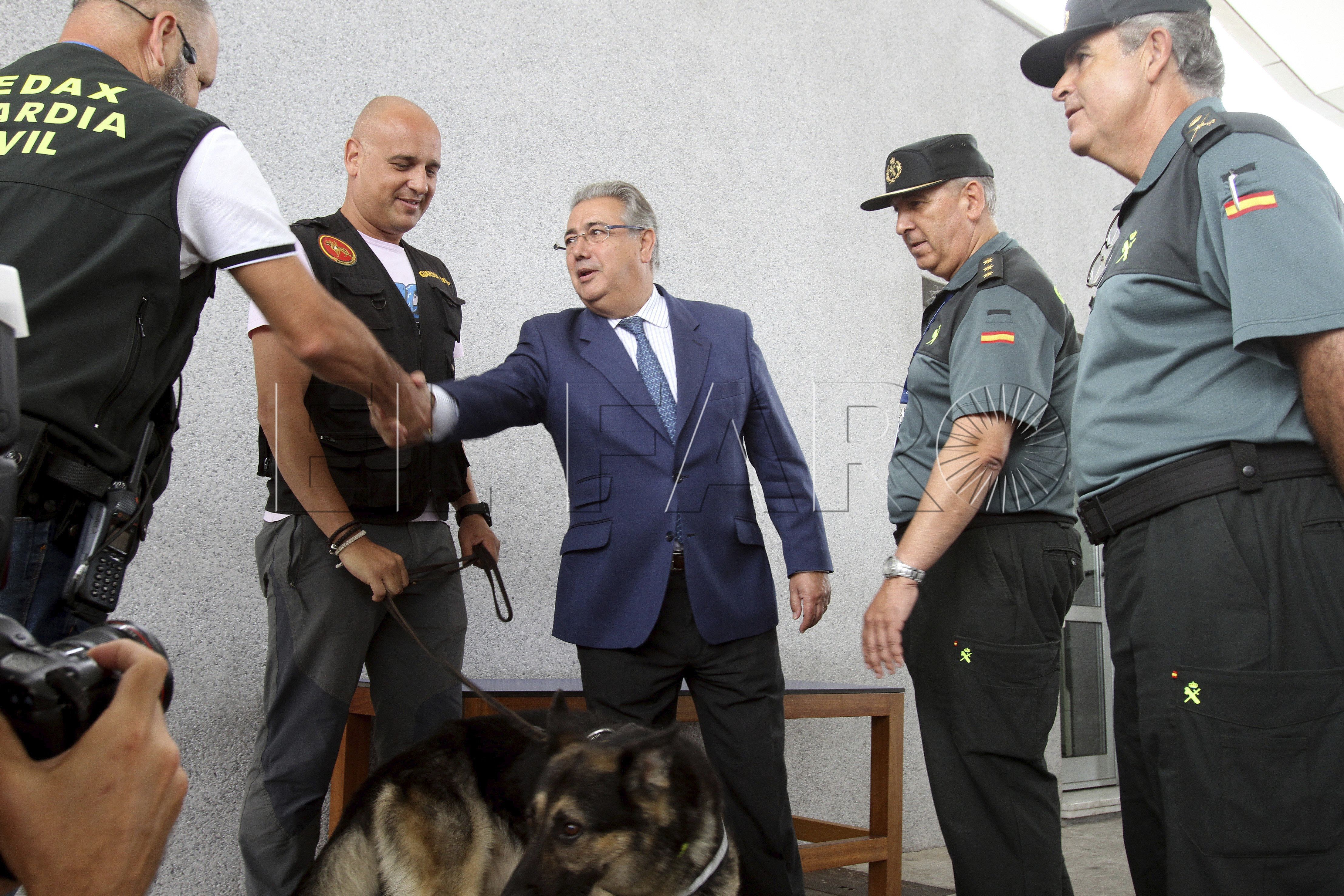 El ministro del Interior, Juan Ignacio Zoido (c) saluda a los guardias civiles y sus perros que controlan explosivos dentro del dispositivo de la Operación Paso del Estrecho (OPE) durante su visita hoy al puerto de Algeciras (Cádiz), donde ha dicho que "roza ya la perfección", después de que haya superado sus días punta sin ningún incidente y con un tiempo máximo de espera para embarcar de dos horas. EFE/J.Ragel