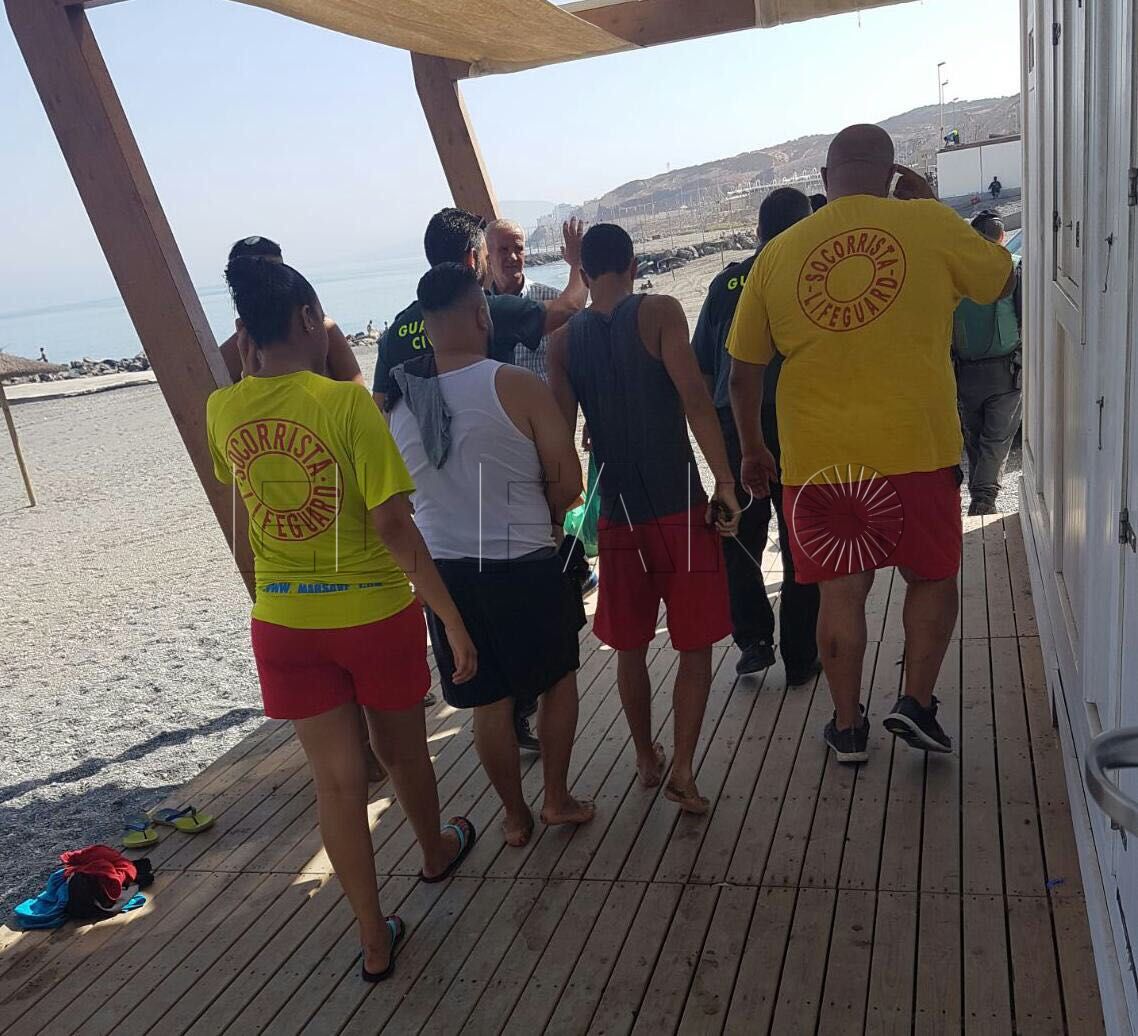 Un piloto de una moto de agua deja a dos inmigrantes en la playa del Tarajal