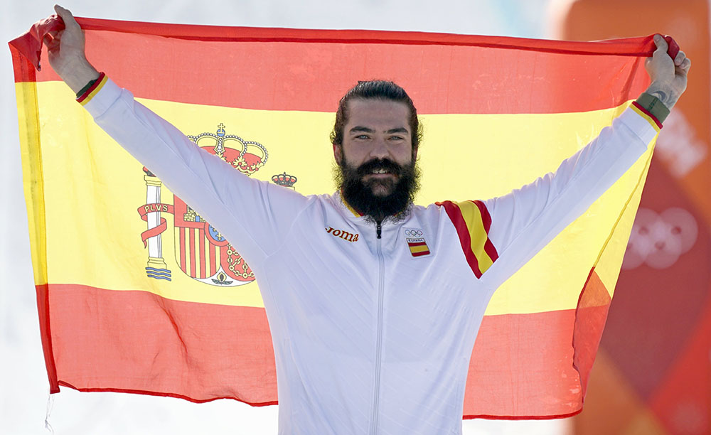 Bongpyeong-myeon (Korea, Republic Of), 15/02/2018.- Bronze medal winner Regino Hernandez of Spain celebrates with the Spanish flag on the podium during the venue ceremony after the Men's Snowboard Cross SBX final at the Bokwang Phoenix Park during the PyeongChang 2018 Olympic Games, South Korea, 15 February 2018. (España, Fénix, Corea del Sur) EFE/EPA/SERGEI ILNITSKY