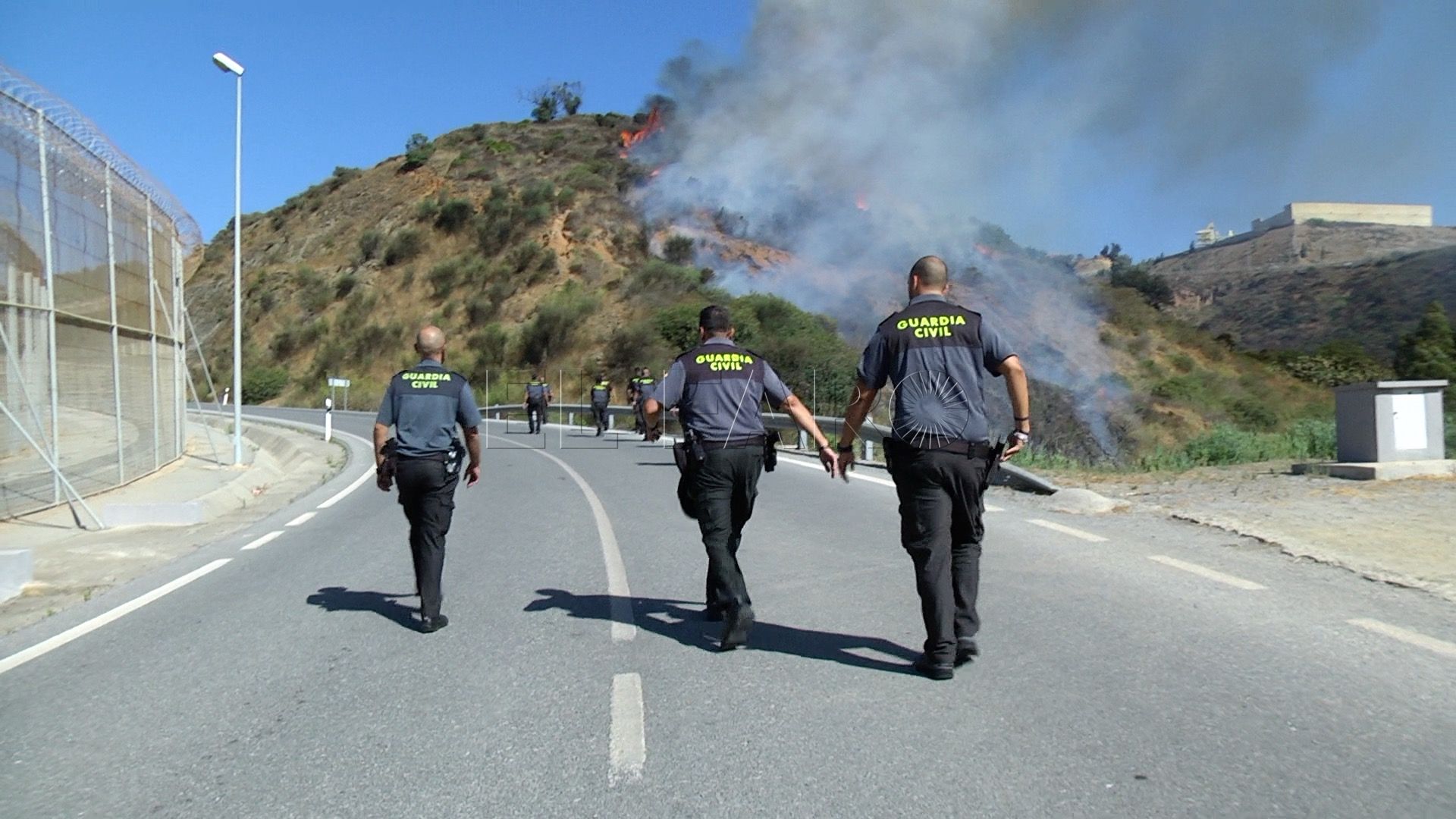 Bomberos sofoca un incendio de monte bajo al lado de la valla
