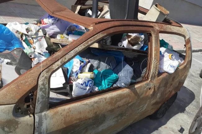 El nuevo uso de los coches abandonados: contenedor de basura